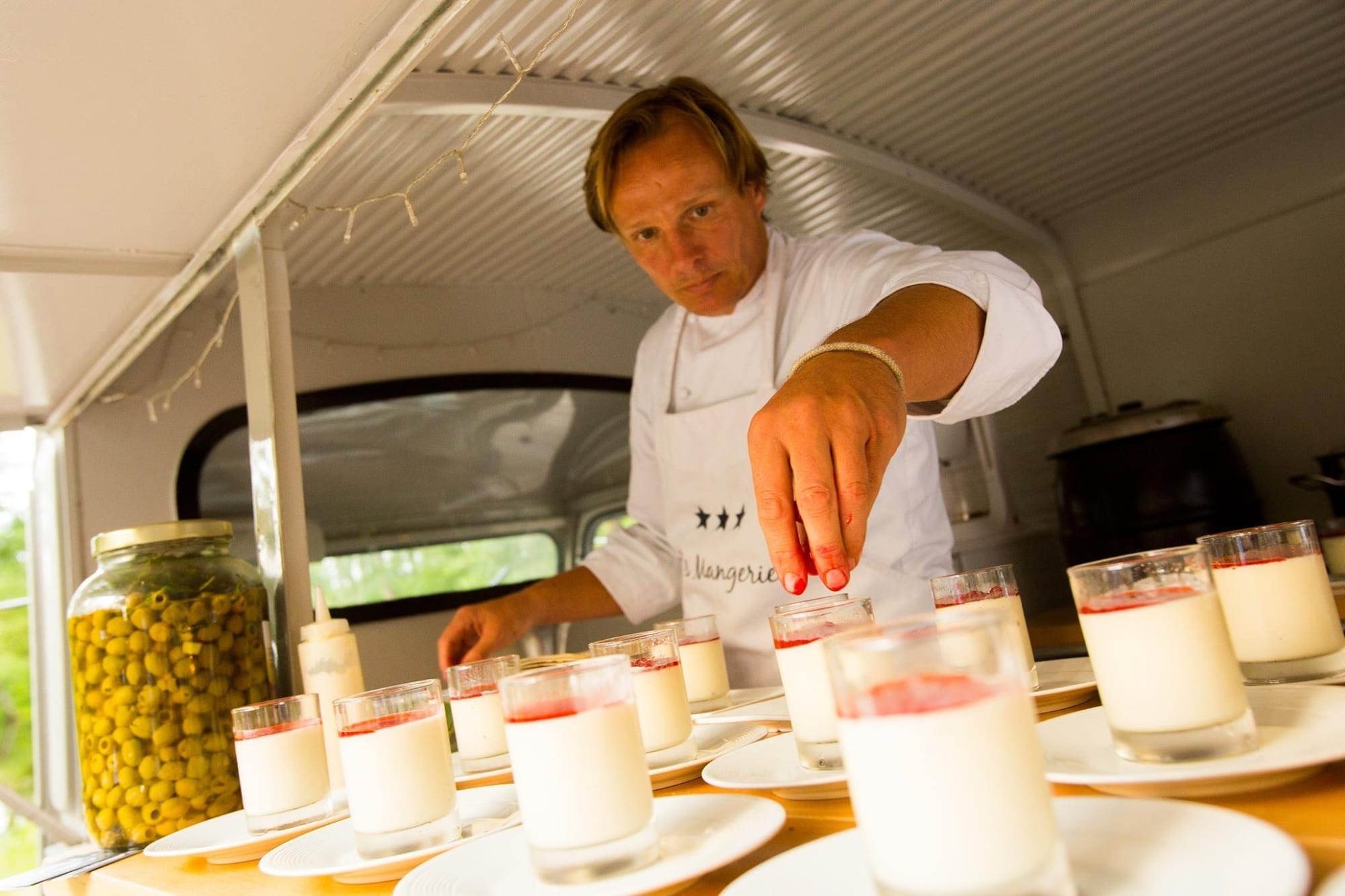 Patrick maakt glazen panna cotta af in de keuken van de Citroën HY