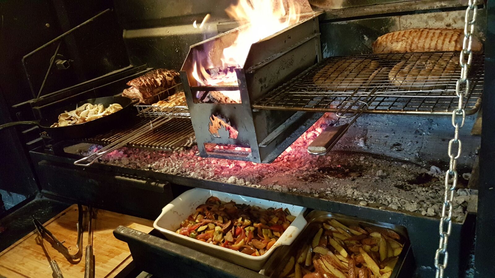 Vlees op het rooster boven gloeiende kolen in de braai